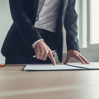 A man pointing at a place on an open document.